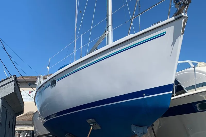 Slide: The Image of 1998 Catalina 320 sailboat on dry dock under clear blue sky. - 7