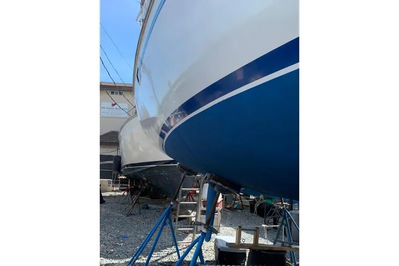 Slide: The Image of 1998 Catalina 320 sailboat on stands, blue and white hull, in a boatyard. - 9