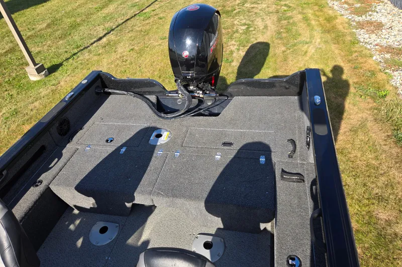 Slide: The Image of 2021 Crestliner 1850 Fish Hawk SC JS boat interior with motor, on grassy area. - 23