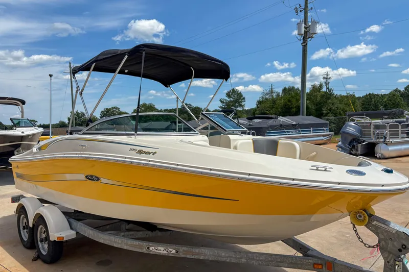 Slide: The Image of 2007 Sea Ray 195 Sport boat with yellow hull on trailer under blue sky. - 3