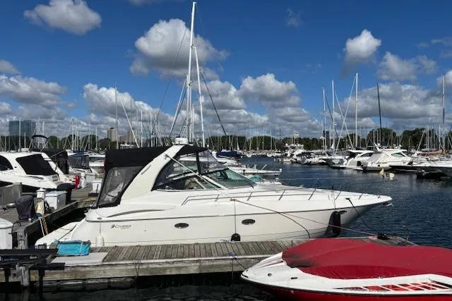 Slide: The Image of 2004 Cruisers Yachts 370 Express docked at a marina under a blue sky. - 0