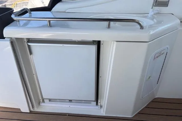 Slide: The Image of 2004 Cruisers Yachts 370 Express wet bar with stainless steel rail and mini fridge. - 11