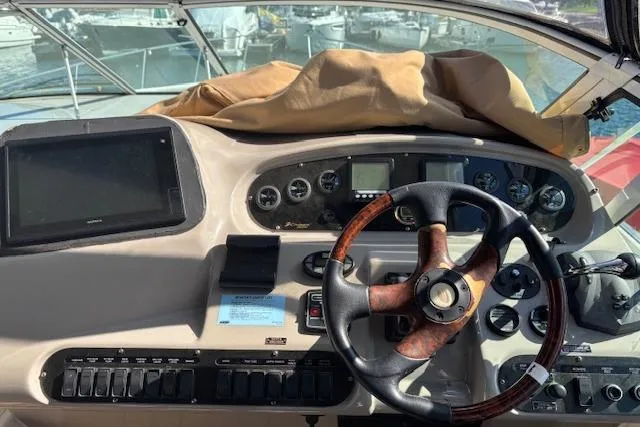 Slide: The Image of 2004 Cruisers Yachts 370 Express helm with steering wheel and navigation controls. - 17