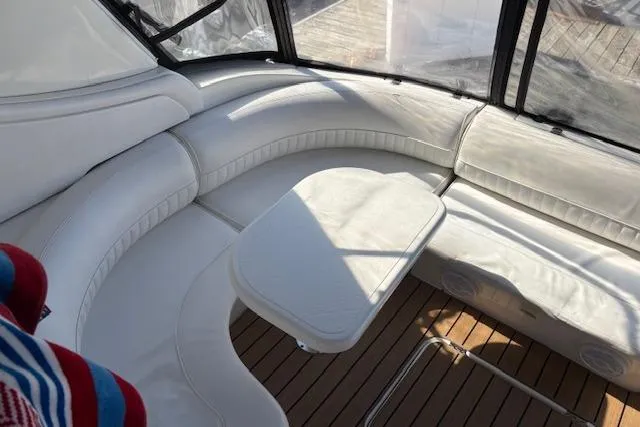 Slide: The Image of 2004 Cruisers Yachts 370 Express interior with white seating and wooden flooring. - 19
