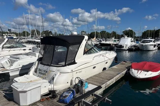 Slide: The Image of 2004 Cruisers Yachts 370 Express docked at marina under blue sky. - 24