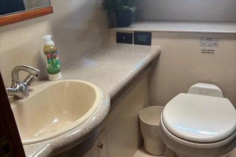 Slide: The Image of 2004 Cruisers Yachts 370 Express bathroom with sink, toilet, and countertop. - 6