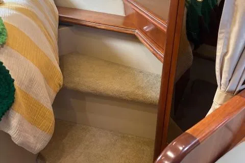 Slide: The Image of Interior stairs of 2004 Cruisers Yachts 370 Express with carpet and wood accents. - 7