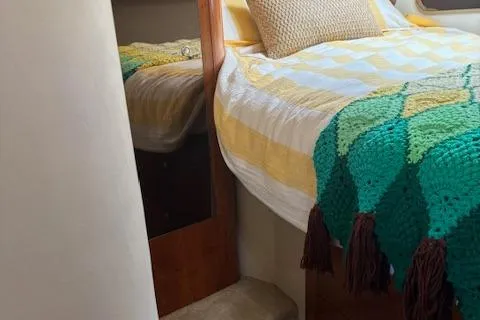 Slide: The Image of 2004 Cruisers Yachts 370 Express cabin with cozy bed and colorful blanket. - 8