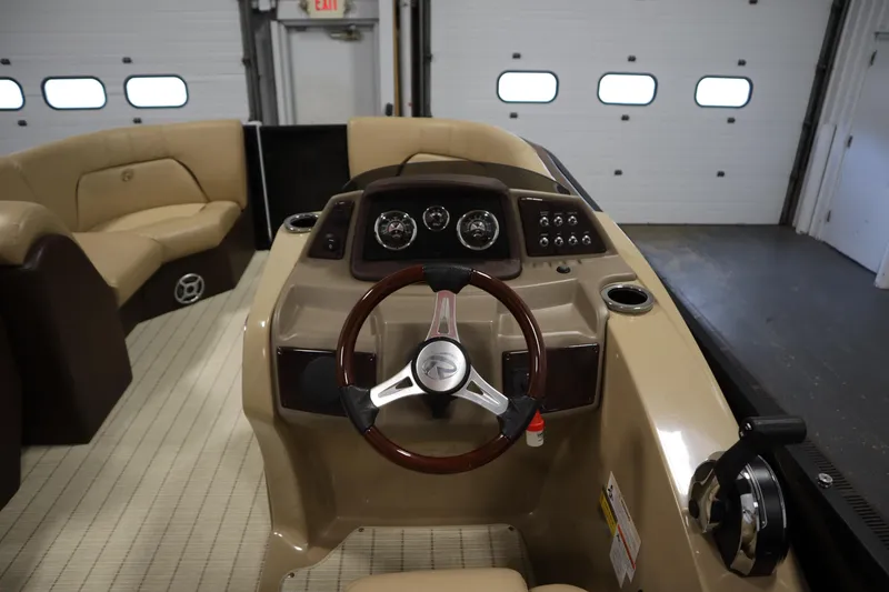 Slide: The Image of Interior view of 2018 Lowe 230 Retreat WT boat, featuring steering wheel and dashboard controls. - 18