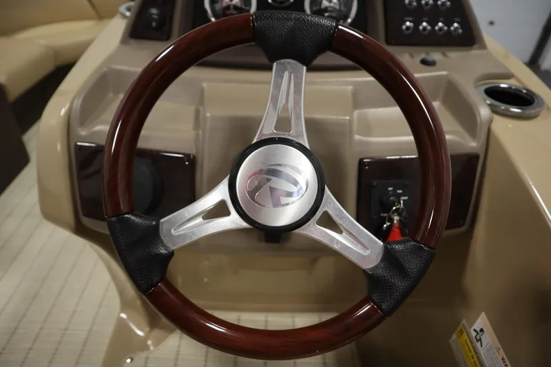 Slide: The Image of Steering wheel of 2018 Lowe 230 Retreat WT boat, featuring wood and metal design. - 19