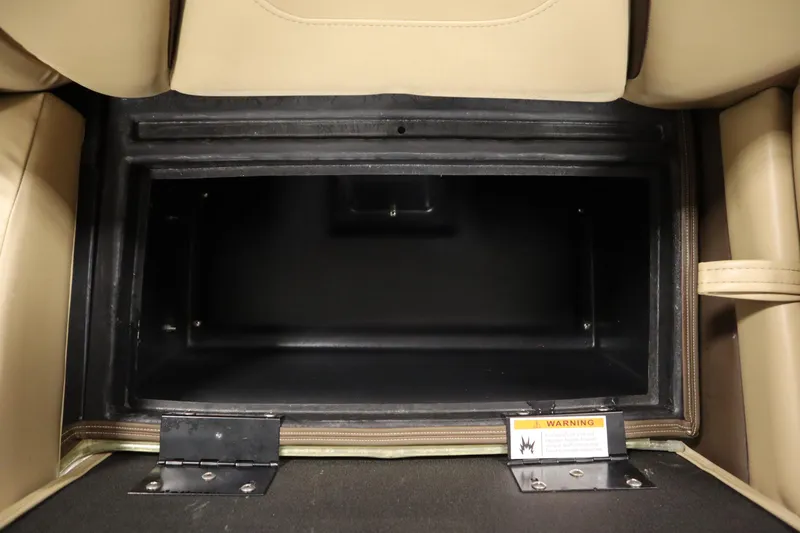 Slide: The Image of Open storage compartment in 2018 Lowe 230 Retreat WT boat, featuring beige seating and warning label. - 33