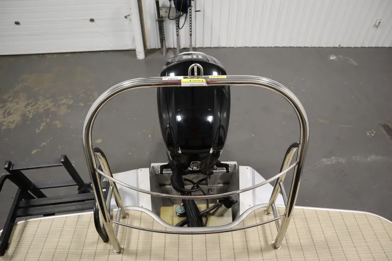 Slide: The Image of 2018 Lowe 230 Retreat WT boat engine with stainless steel railing in a garage. - 37