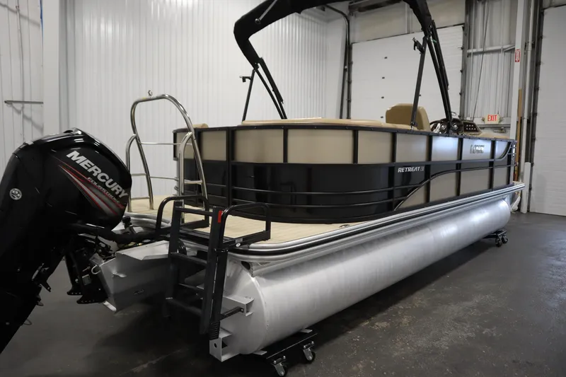 Slide: The Image of 2018 Lowe 230 Retreat WT pontoon boat with Mercury outboard motor in a garage setting. - 4