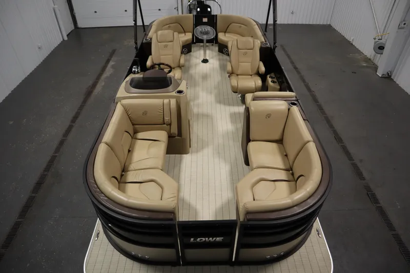 Slide: The Image of 2018 Lowe 230 Retreat WT pontoon boat with beige seating in a garage setting. - 8
