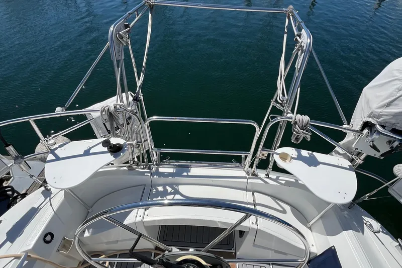 Slide: The Image of 1988 Hunter 37.5 sailboat cockpit with steering wheel, stainless steel railings, and water view. - 15