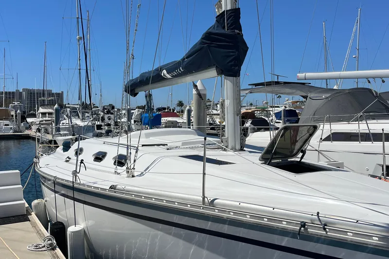 Slide: The Image of 1988 Hunter 37.5 sailboat docked in marina, clear blue sky background. - 2