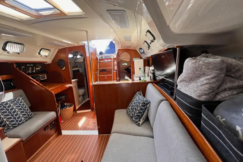 Slide: The Image of Interior of a 1988 Hunter 37.5 sailboat, featuring cozy seating and wooden finishes. - 21