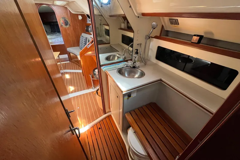 Slide: The Image of Interior of 1988 Hunter 37.5 sailboat with wooden finishes and compact amenities. - 23