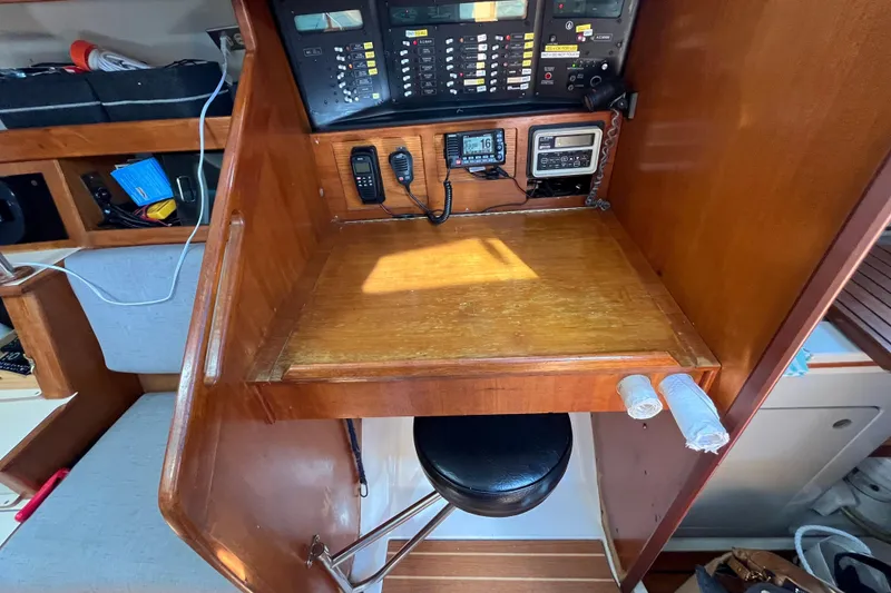 Slide: The Image of Navigation station inside 1988 Hunter 37.5 sailboat with communication equipment and wooden desk. - 27