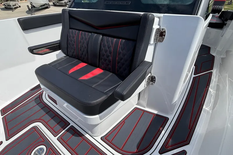 Slide: The Image of Luxurious seating on 2026 Monterey Elite 27 OB boat with stylish black and red design. - 18