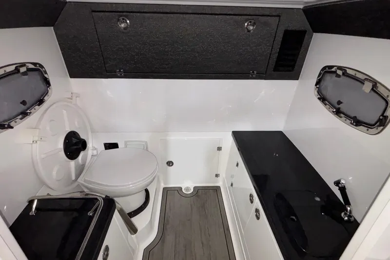 Slide: The Image of 2026 Monterey Elite 27 OB boat interior with toilet, sink, and storage compartments. - 30