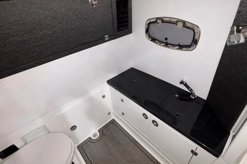 Slide: The Image of 2026 Monterey Elite 27 OB boat bathroom with sleek black countertop and compact design. - 31