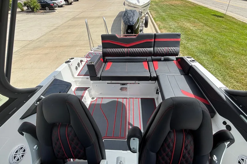Slide: The Image of 2026 Monterey Elite 27 OB boat interior with black and red seating, docked outdoors. - 7