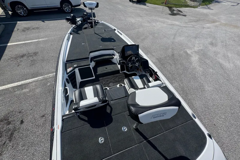Slide: The Image of 2026 Skeeter FXR20 FLEX boat interior with seating and control panel in a parking lot. - 13