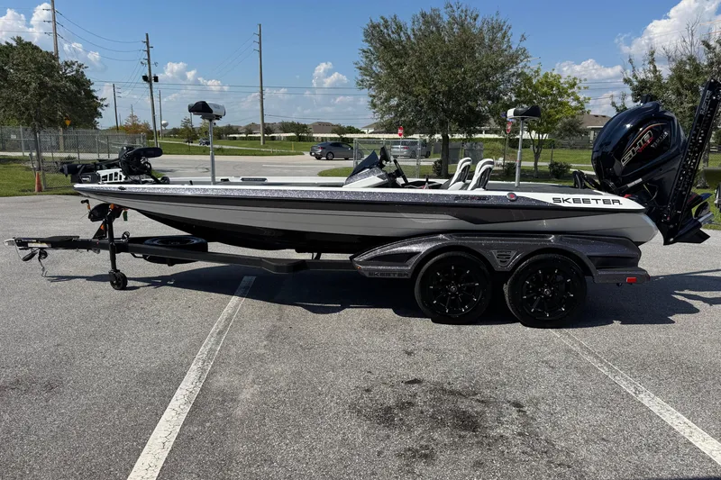 Slide: The Image of 2026 Skeeter FXR20 FLEX boat on trailer in parking lot, sunny day. - 18