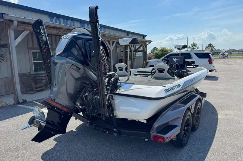 Slide: The Image of 2026 Skeeter FXR20 FLEX boat on trailer, parked outside a building under a clear sky. - 21
