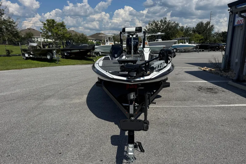Slide: The Image of 2026 Skeeter FXR20 FLEX boat on trailer in parking lot under blue sky. - 4