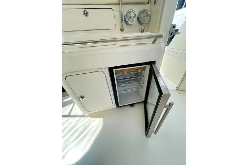 Slide: The Image of 2001 Sea Ray 420 Aft Cabin yacht interior with open mini fridge and storage compartments. - 10