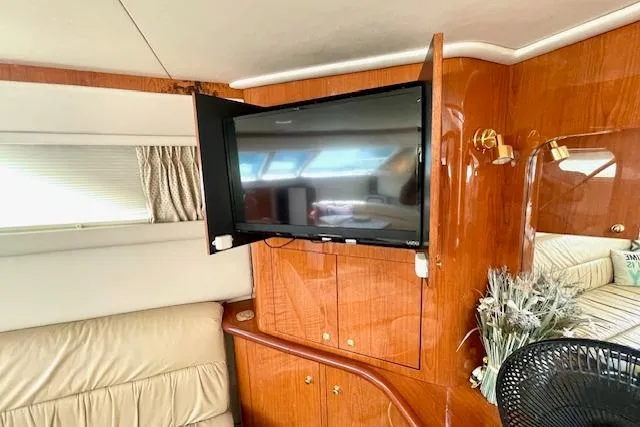 Slide: The Image of Interior of 2001 Sea Ray 420 Aft Cabin with TV and wooden cabinetry. - 23
