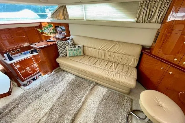 Slide: The Image of Luxurious interior of 2001 Sea Ray 420 Aft Cabin with beige sofa and elegant wood finishes. - 24