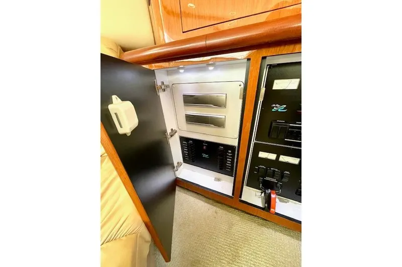 Slide: The Image of Electrical panel inside 2001 Sea Ray 420 Aft Cabin yacht, featuring control switches and storage. - 26