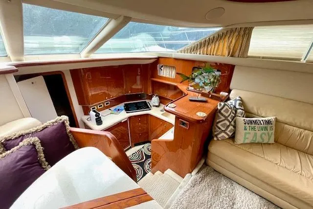 Slide: The Image of Luxurious 2001 Sea Ray 420 Aft Cabin interior with cozy seating and modern kitchen amenities. - 28
