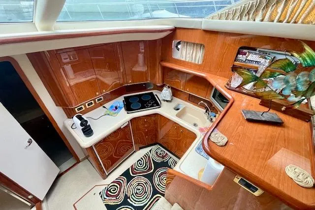 Slide: The Image of 2001 Sea Ray 420 Aft Cabin kitchen with wood cabinetry and modern appliances. - 29
