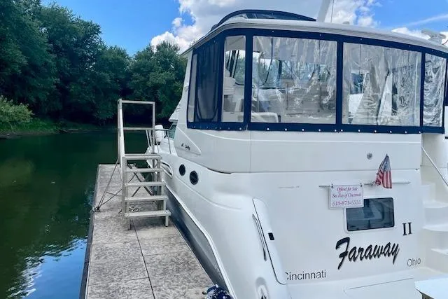 Slide: The Image of 2001 Sea Ray 420 Aft Cabin docked by a serene river with lush greenery. - 3