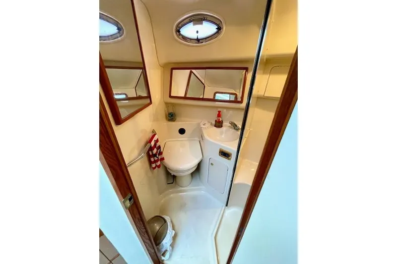 Slide: The Image of 2001 Sea Ray 420 Aft Cabin bathroom with toilet, sink, and mirror. - 34