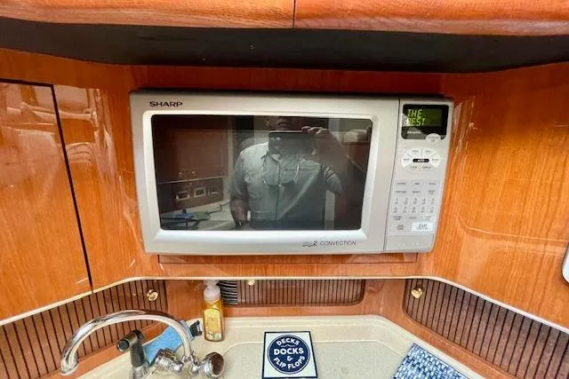 Slide: The Image of 2001 Sea Ray 420 Aft Cabin kitchen with Sharp microwave and sink. - 37