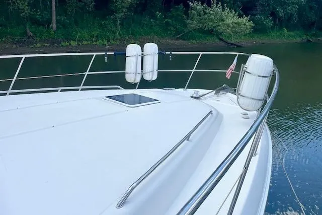 Slide: The Image of 2001 Sea Ray 420 Aft Cabin yacht deck with railing and fenders on calm water. - 4