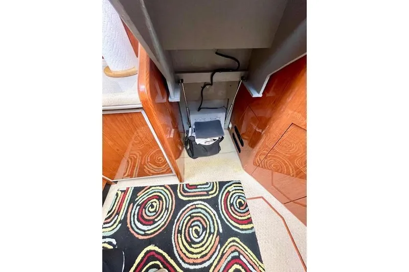 Slide: The Image of Interior of 2001 Sea Ray 420 Aft Cabin with colorful spiral rug and wooden cabinetry. - 41