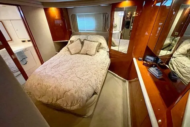 Slide: The Image of Luxurious 2001 Sea Ray 420 Aft Cabin bedroom with elegant wood finishes and cozy bedding. - 42