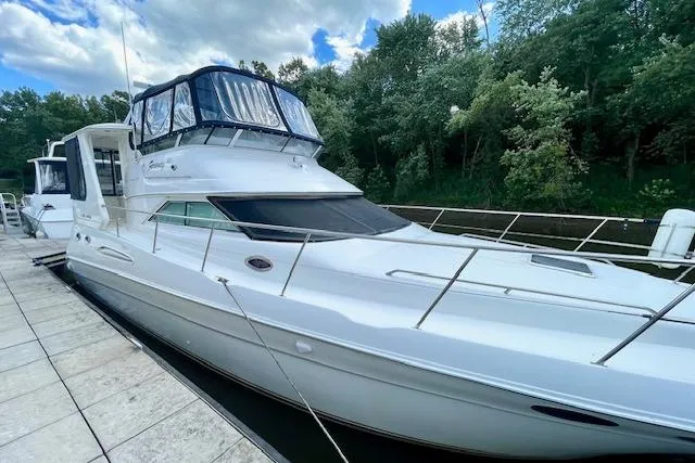 Slide: The Image of 2001 Sea Ray 420 Aft Cabin yacht docked by lush greenery. - 5