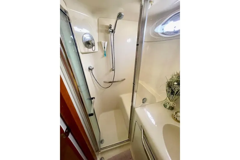 Slide: The Image of Bathroom shower in 2001 Sea Ray 420 Aft Cabin yacht, featuring modern fixtures and porthole window. - 50