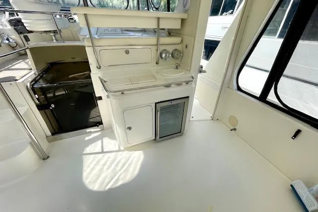 Slide: The Image of 2001 Sea Ray 420 Aft Cabin interior with kitchenette and seating area. - 9