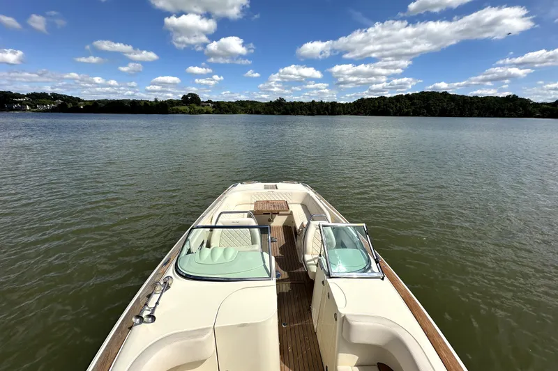Slide: The Image of 2019 Chris-Craft Launch 30 on serene lake under blue sky with clouds. - 14