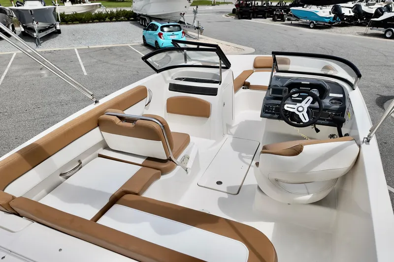 Slide: The Image of 2021 Bayliner VR5 Bowrider OB interior with tan seating and modern dashboard. - 8