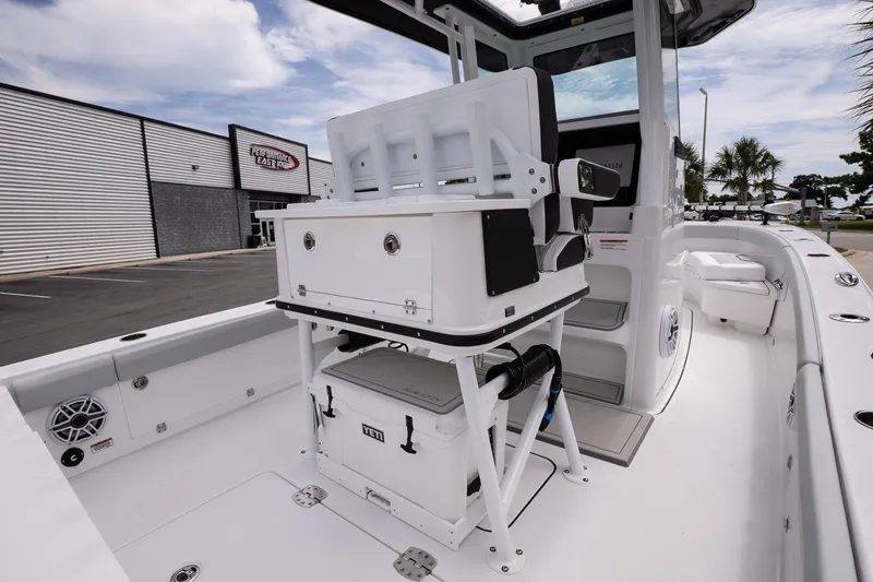 Slide: The Image of 2026 Blackfin 262 HB boat interior with seating and storage, docked near a marine store. - 18
