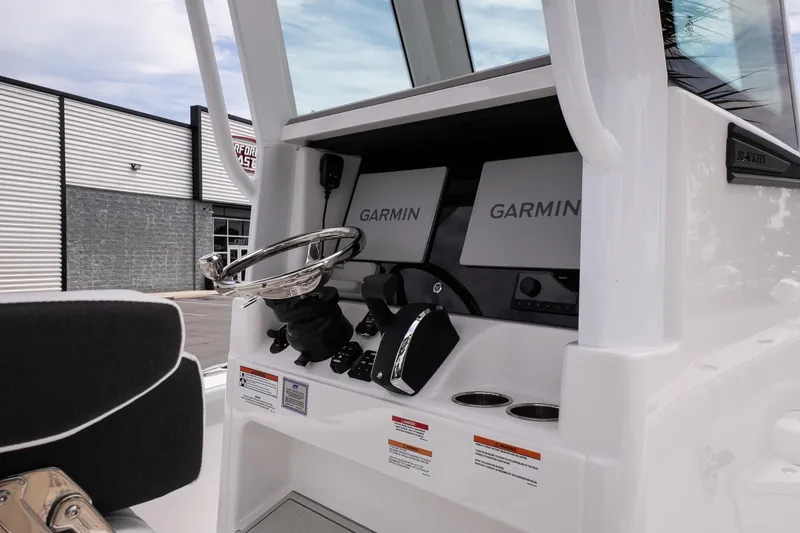 Slide: The Image of 2026 Blackfin 262 HB boat dashboard with Garmin navigation displays and steering wheel. - 24